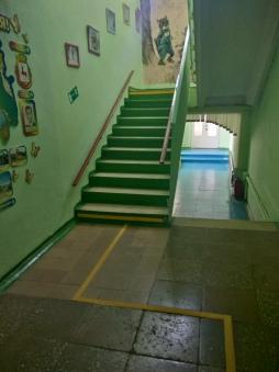 В здании детского сада размещены тактильные напольные указатели перед спуском/подъемом на лестничных маршах. Поручни-направляющие на межэтажных лестницах с двух сторон     позволяют преодолевать лестницы.